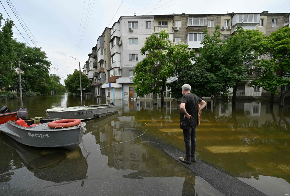 A local resident looks at a flooded street in the town of Kherson on June 10, 2023, following damages sustained at the Kakhovka hydroelectric power plant dam. The flood triggered by damage to the Kakhovka dam in the early hours of June 6, 2023 forced thousands to flee, disrupted water supplies and sparked fears of an environmental and humanitarian disaster. — AFP pic 