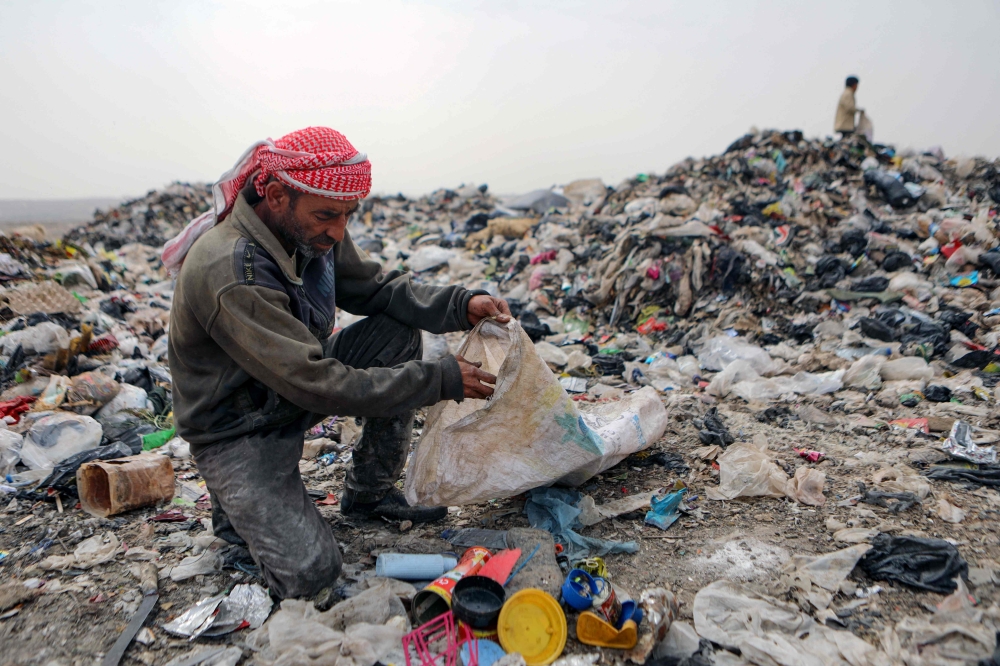In this picture taken on June 3, 2023, Mohammed Behlal, 39, sifts through rubbish looking for plastic items to sell, at a dump site near the village of Hazreh in Syria’s north-western Idlib province. — AFP pic 