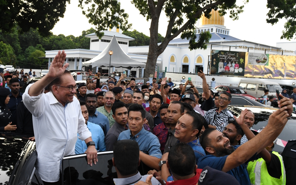 Prime Minister Datuk Seri Anwar Ibrahim waves to the crowd during a meet and greet session in Balik Pulau June 11, 2023. — Bernama pic