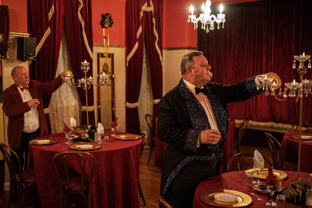 Hotel owners Mark Hinds (left) and Jacques Rabie light up candles inside the Grimaldi's theatre at the Karroo Theatrical Hotel. — AFP pic