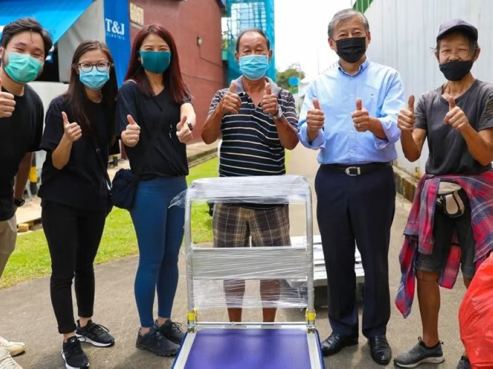 A photo from George Goh's website showing him (second from right) distributing new trolleys to cardboard collectors. — Picture by Goh Ching Wah via TODAY