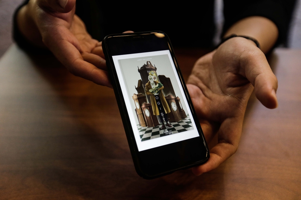 Jared Lee shows a poster from his latest animated short film ‘Horologist’. ― Picture by Sayuti Zainudin