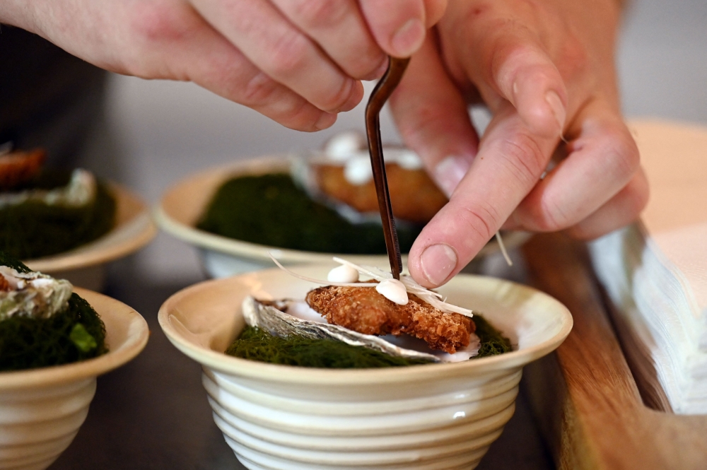 A chef prepares fried oysters at the kitchen of the Mota restaurant. — AFP pic 