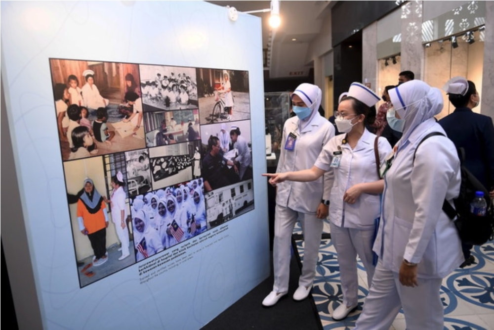 Nurses look at a display of the evolution of the nurses’ uniform at Muzium Negara in Kuala Lumpur on May 12, 2022. — Bernama pic