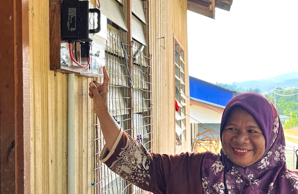Villager Andak Anjang, 48, shows an electricity meter outside her house at Pos Tuel, Gua Musang June 16, 2023. — Bernama pic