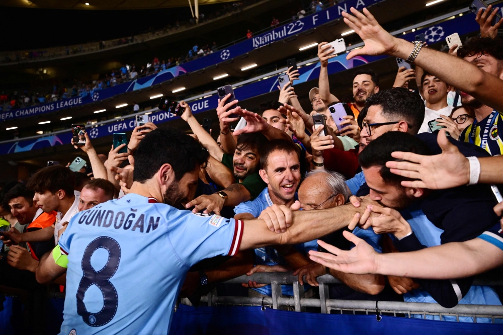 Manchester City's German midfielder #8 Ilkay Gundogan celebrates with the fans after winning the UEFA Champions League final football match between Inter Milan and Manchester City at the Ataturk Olympic Stadium in Istanbul June 10, 2023. — AFP pic