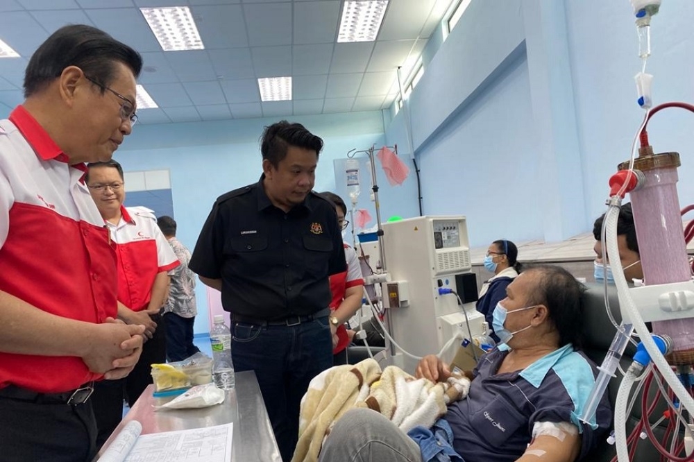 Lukanisman Awang Sauni (centre) talks to a dialysis patient at Permyjaya MRC Dialysis Centre while Transport Minister Datuk Seri Lee Kim Shin (left) looks on. — Borneo Post pic
