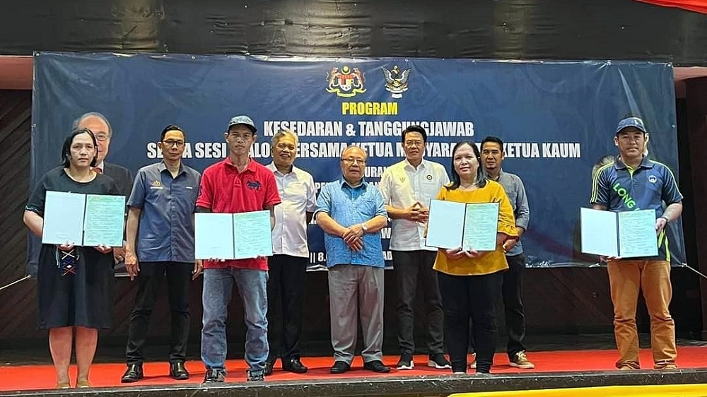 Ruran Lukas (left) and her siblings (holding birth certificates) in a photocall with Lawas MP Datuk Henry Sum Agong (centre) and others. — Borneo Post pic