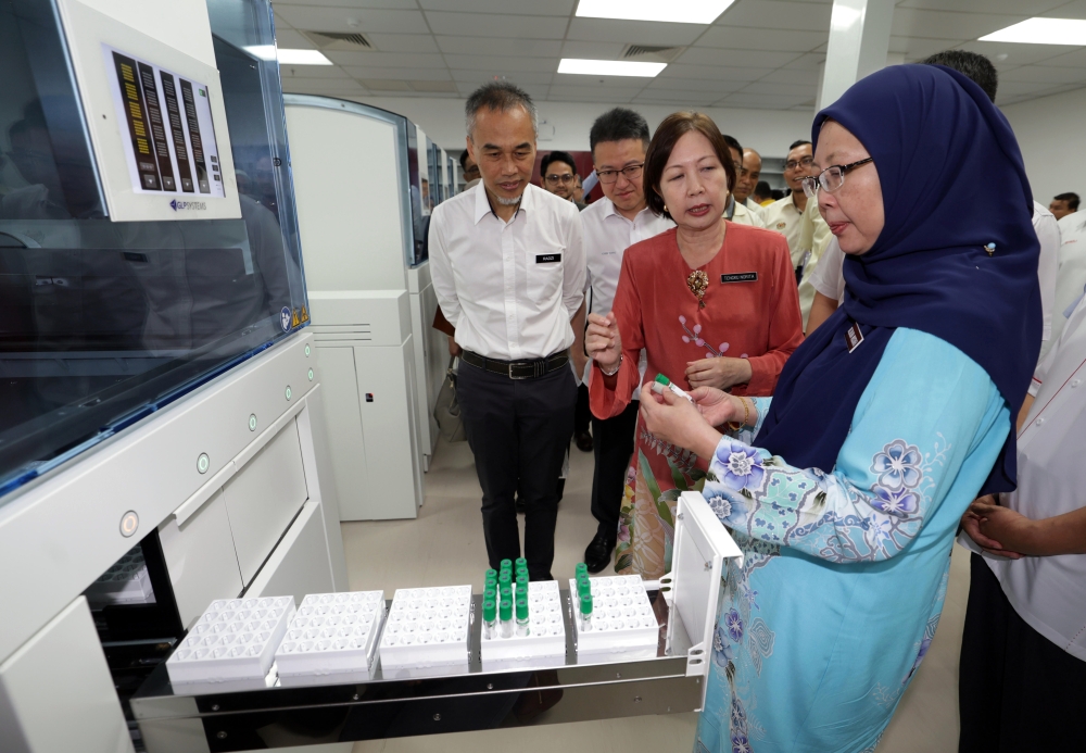 Health Minister Dr Zaliha Mustafa (right) inspects a machine that processes blood samples during the handover ceremony for Sultanah Aminah Hospital (HSA) Pathology laboratory project, Taman Ungku Tun Aminah Health Clinic and Palong Timur Health Clinic at HSA in Johor Baru June 18, 2023. — Bernama pic