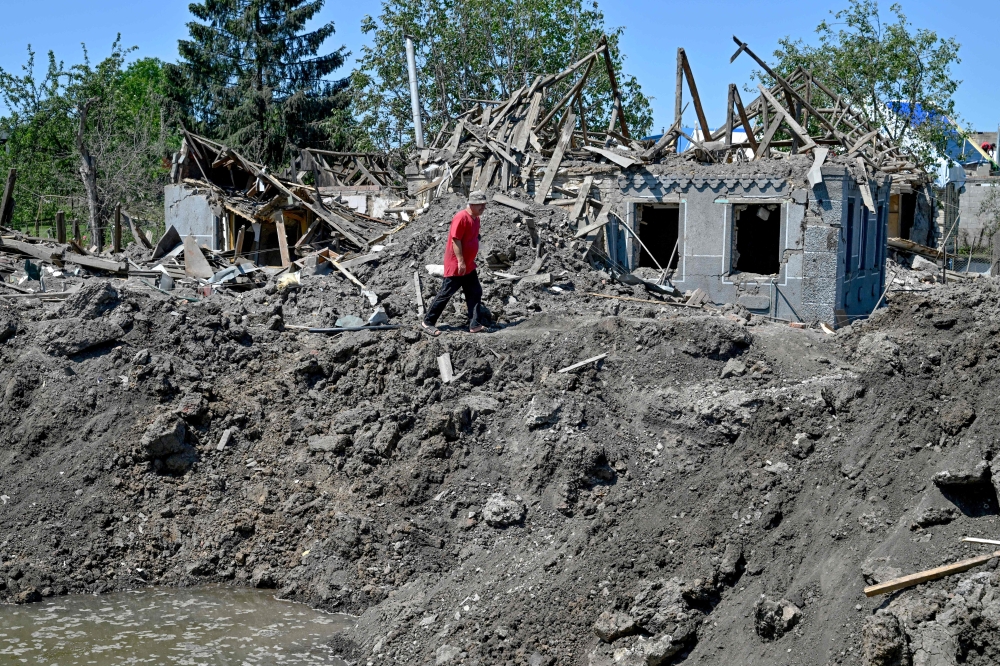 A man walks past debris of a house destroyed by an earlier Russian missile attack, in the town of Kramatorsk. — Reuters pic
