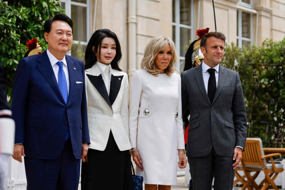 South Korean President Yoon Suk Yeol (left), his wife Kim Keon-hee (second from left), French President Emmanuel Macron (right) and his wife Brigitte Macron (second from right) pose during a working lunch meeting at the Elysee Palace in Paris June 20, 2023. — AFP pic