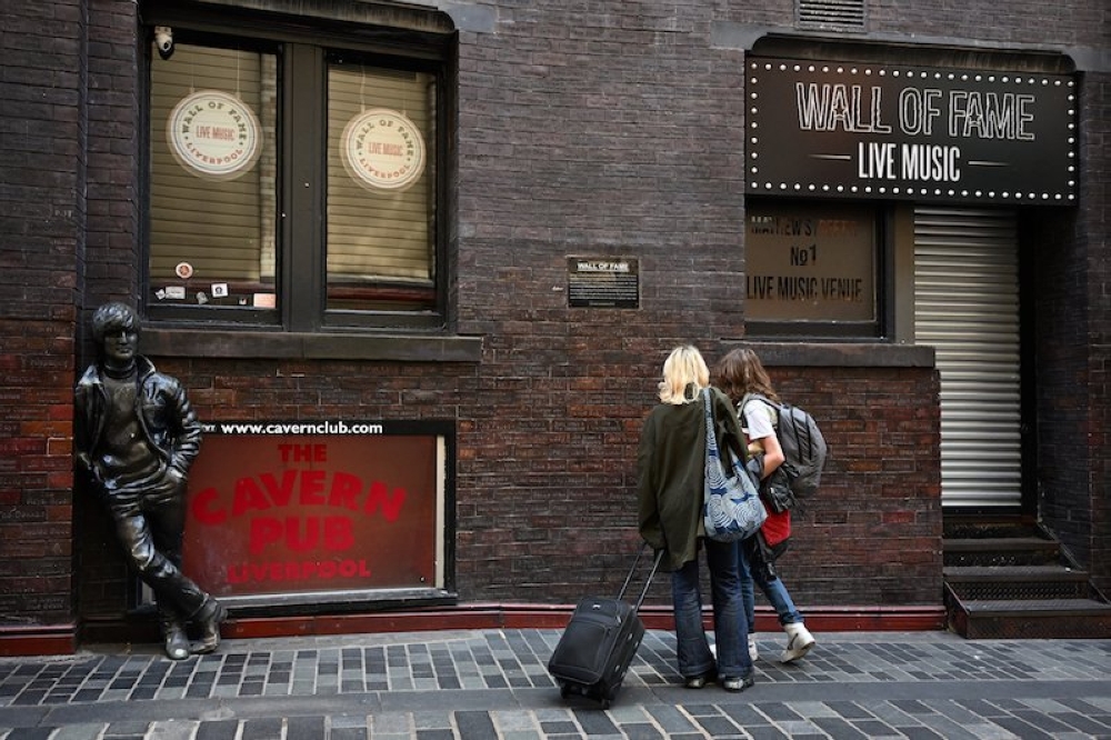 Tourists walk past the Music Wall of Fame in Mathew Street, in Liverpool June 14, 2023. — AFP pic