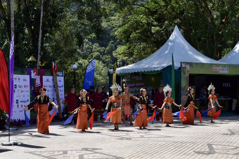 Dancers welcome festival-goers at the entrance of the Sarawak Cultural Village. — Borneo Post pic