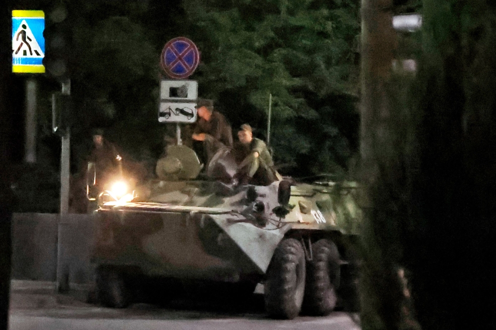 Russian servicemen sit atop of an armoured personnel carrier parked in a street in the city of Rostov-on-Don, early on June 24, 2023. — AFP pic