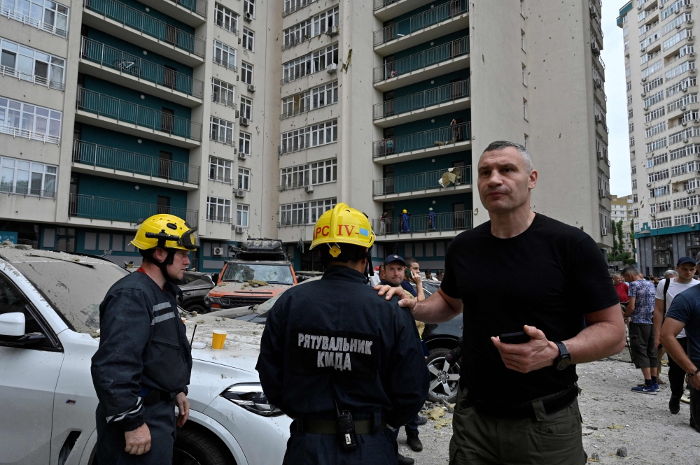 Kyiv’s Mayor Vitali Klitschko talks with rescuers next to a 24-storey building partially destroyed following a Russian missiles strike in Kyiv early on June 24, 2023.. — AFP pic