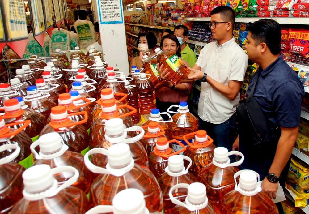 Gopeng MP Tan Kar Hing (2nd right) and Simpang Pulai DUN Wong Chai Yi inspect cooking oil on offer for RM25.99 compared to its usual price of RM29.20 during Rahmah Sales at at Billion Mart in Ipoh June 24, 2023. — Bernama pic