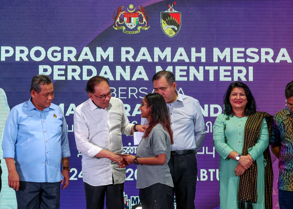 Prime Minister Datuk Seri Anwar Ibrahim (2nd left) presents an award to outstanding SPM 2022 students at a meet-and-greet session with the Indian community at Desa Cempaka, Nilai