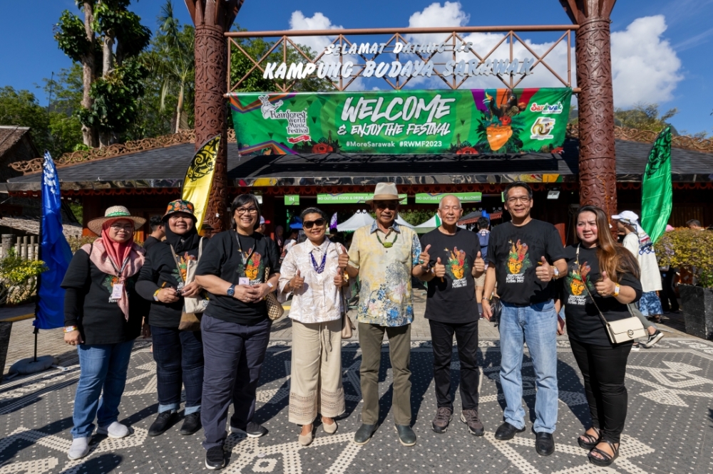 Sharzede 3ird left) and Abdul Karim (4th right) in a photocall upon arrival at the Sarawak Cultural Village today for a walkabout at the RWMF event grounds. — Borneo Post pic