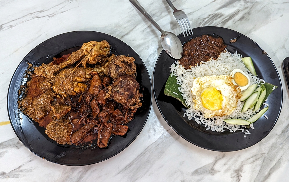 A mountain of 'lauk' and a humble plate of 'nasi lemak' on the side. — Pictures by Ethan Lau
