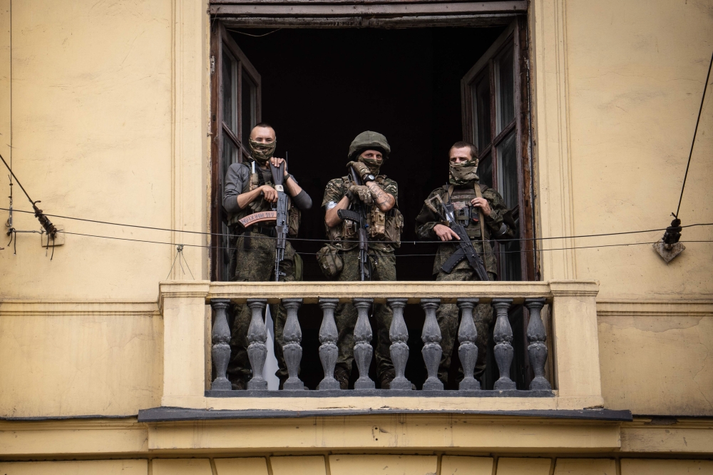 Members of the Wagner group stand on the balcony of a building in the city of Rostov-on-Don on June 24. — AFP pic