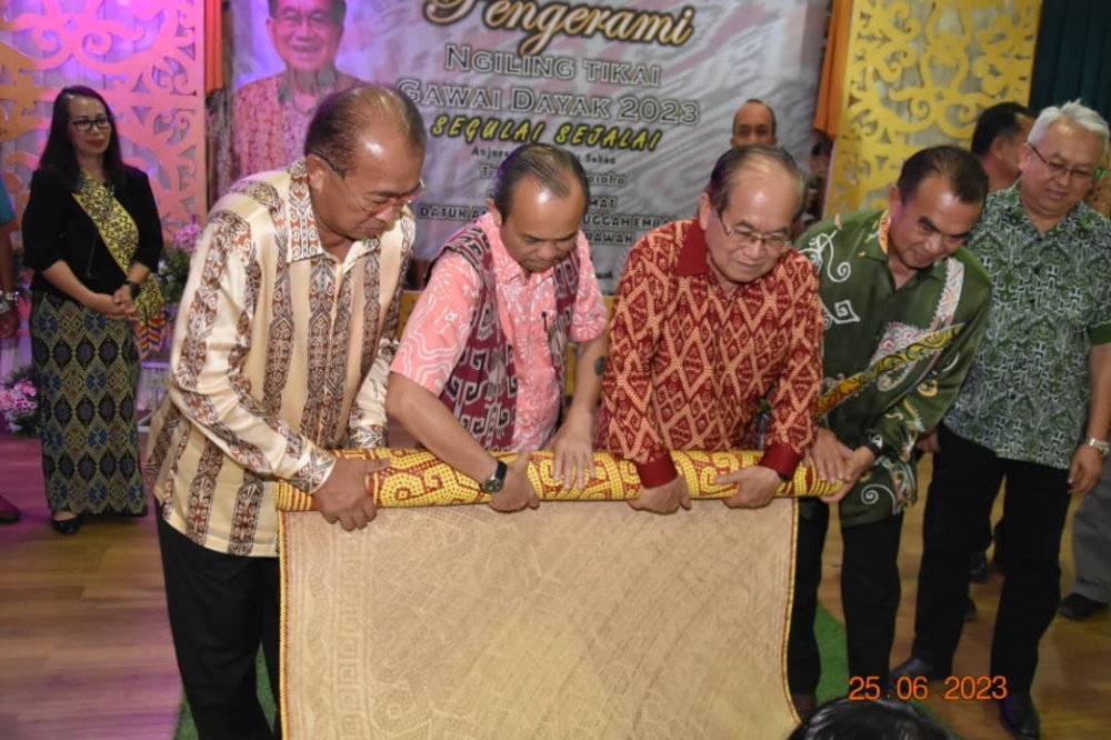 Uggah (third left) joins (from left) Mulok, Richard and Robert in the ‘ngiling tikai’ ritual, which symbolises the end of Gawai Dayak festivities. — Borneo Post Online pic