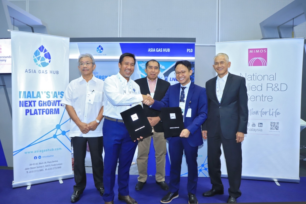 AGH chief executive Faris Mustaffa (2nd left) shakes hands with Mimos chief executive Iskandar Samad after a signing ceremony in Kuala Lumpur June 26, 2023. — Picture courtesy of Asia Gas Hub