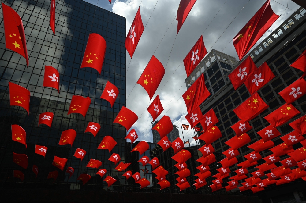 Chinese and Hong Kong flags are strung between buildings to mark the 26th anniversary of the city's handover from Britain to China, in Hong Kong on June 27, 2023. — AFP pic