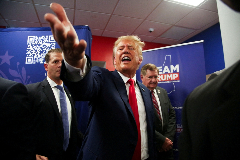 Former US President and Republican presidential candidate Donald Trump greets the crowd during the opening of his campaign headquarters in Manchester, New Hampshire June 27, 2023. — Reuters pic