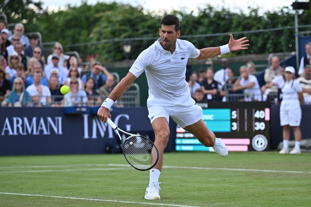 Novak Djokovic dari Serbia kembali kepada pemain AS Frances Tiafoe semasa perlawanan pameran perseorangan lelaki mereka di kejohanan Tenis Klasik Giorgio Armani di Kelab Hurlingham di London pada 29 Jun 2023. — Gambar AFP