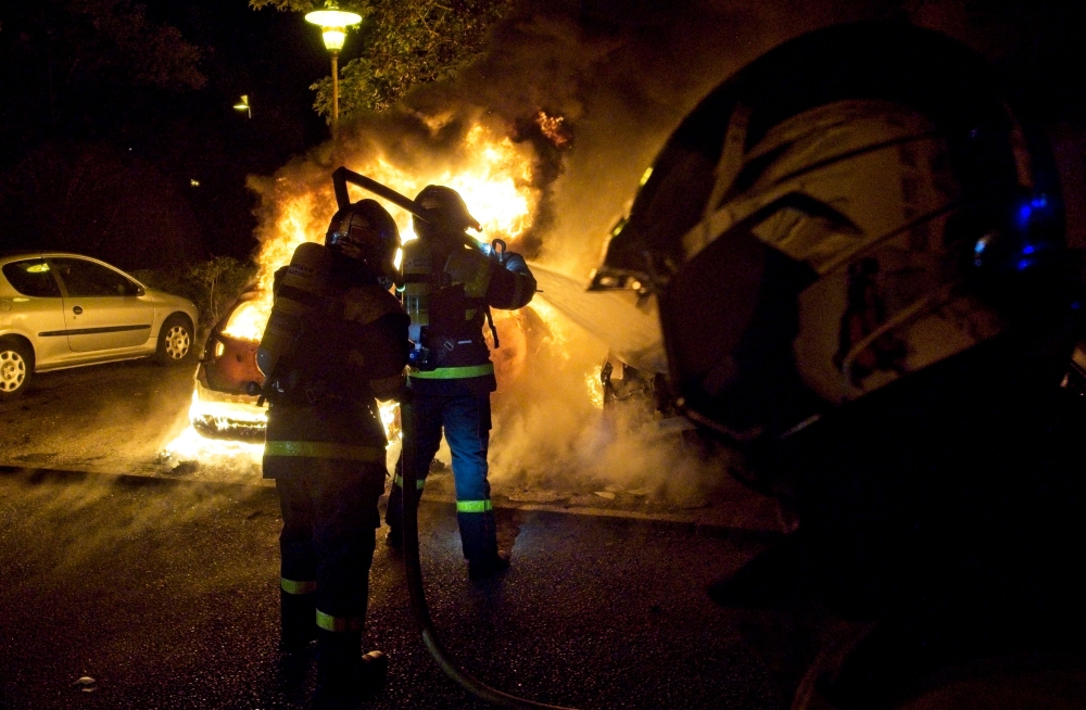 Anggota bomba memadamkan api pada kenderaan yang dibakar semasa protes ganas pada 30 Jun 2023 di Tours, Perancis, tiga hari selepas seorang lelaki berusia 17 tahun dibunuh oleh polis di Nanterre, pinggir barat Paris.  — Gambar AFP
