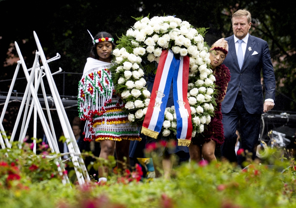 Netherlands’ King Willem-Alexander (right) lays a wreath during the National Remembrance Day of Slavery in The Oosterpark, Amsterdam on July 1, 2023. — AFP pic