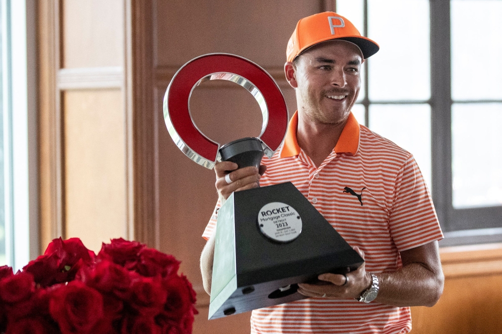 Rickie Fowler picks up the championship trophy after winning the Rocket Mortgage Classic at Detroit Golf Club in Detroit on Sunday, July 2, 2023. — Junfu Han-USA TODAY Sports pic
