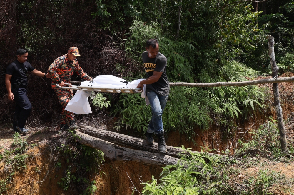 Rescuers carry the body of a victim of the Jeram Air Putih water surge in Sungai Teladas, Chukai, July 3, 2023. — Bernama pic 