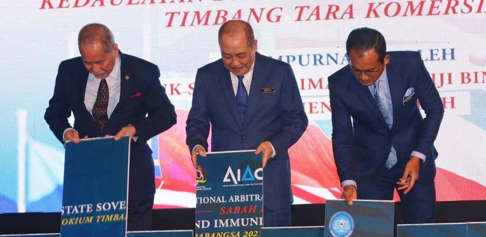 Hajiji with Wan Junaidi (left) and Khairul doing the colloquium launching. . — Borneo Post Online pic