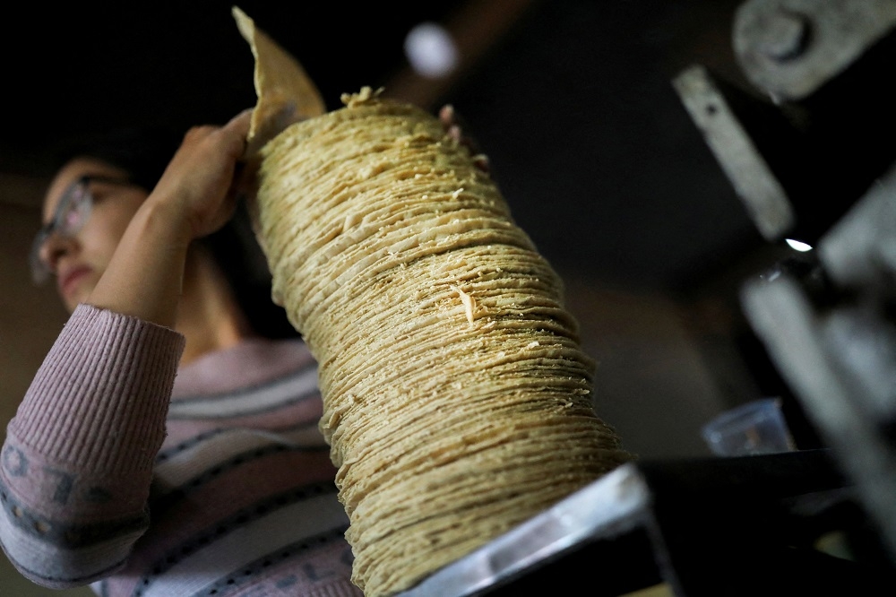 A woman prepares tortillas to be packaged in a family tortilla factory at La Constitucion Totoltepec neighbourhood, in Toluca, Mexico August 3, 2022. ― Reuters pic