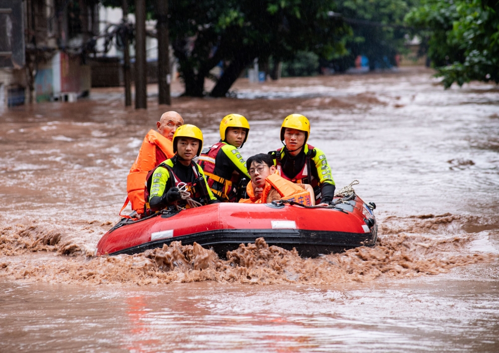Rescue workers evacuate stranded residents on a flooded street after heavy rainfall in Wanzhou district of Chongqing, China July 4, 2023. — Reuters pic