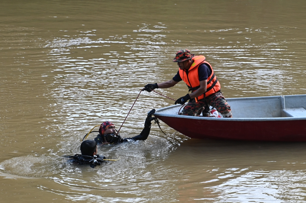 Divers from the Fire and Rescue Department conduct a search and rescue (SAR) operation for victims who were feared to have drowned in the Jeram Mawar water surge on the fourth day in Kampung Seberang Tayor, Kemaman, July 5, 2023. — Bernama pic 