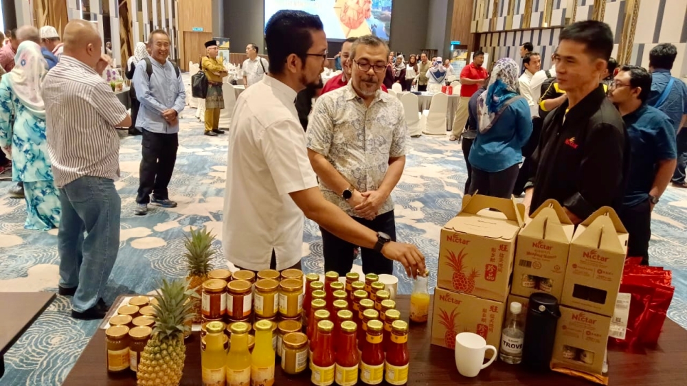 Malaysian Pineapple Industry Board chairman Sheikh Umar Bagharib Ali (left) with a participant at the 2030 Pineapple Industry Development Roadmap workshop held in Johor Baru, July 6, 2023. — Picture by Ben Tan