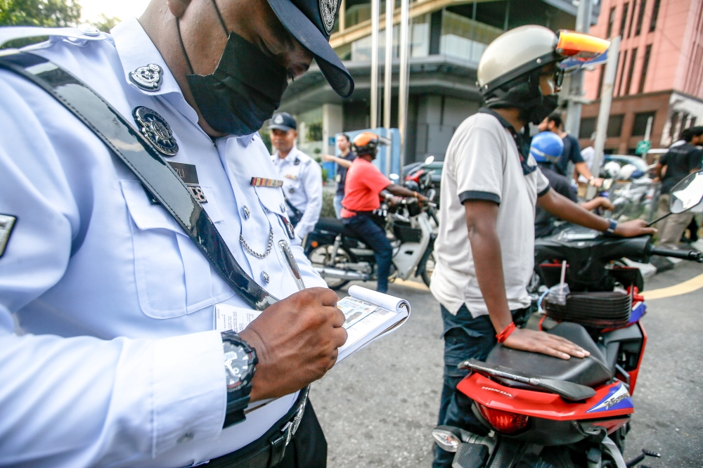 پرسنل اداره نظارت و بازرسی ترافیک شهر در حال صدور احضاریه برای یک راننده در حین انسداد جاده در مرکز شهر، 5 ژوئیه 2023. — تصویر توسط Hari Angara