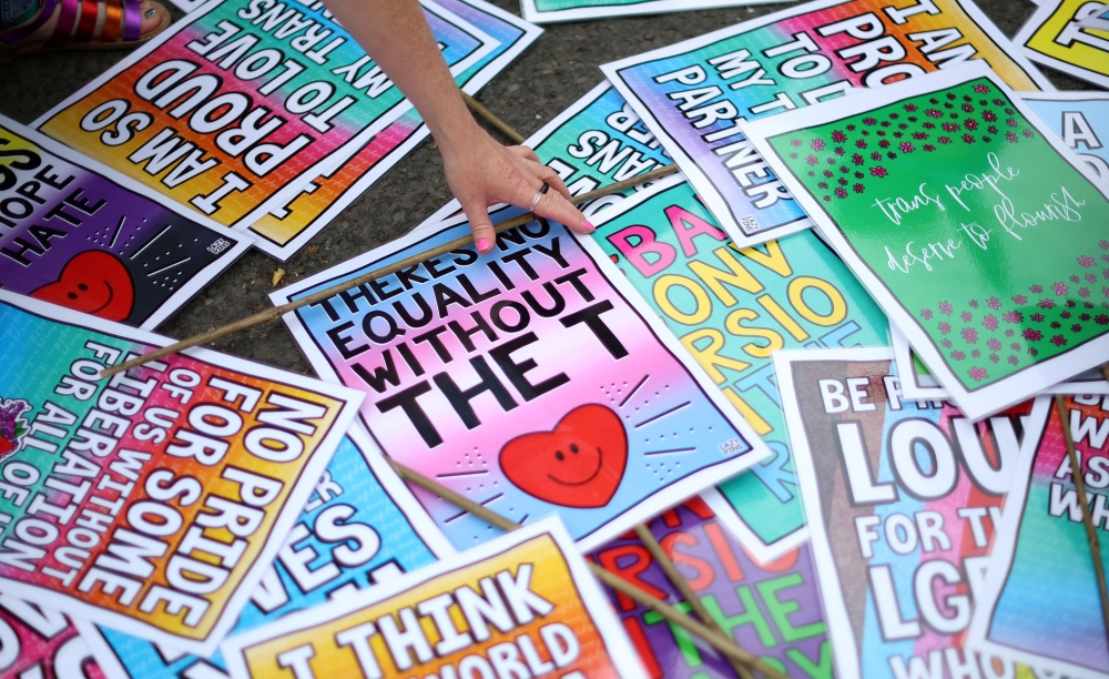 A person picks up a placard ahead of a ‘Trans Joy March’ as part of the Sparkle, a gender diversity festival in Manchester, Britain, July 8, 2023. — Reuters pic