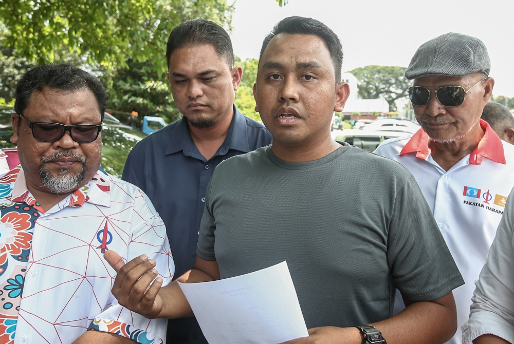 Ipoh Timur MP Howard Lee’s political secretary, Mohamad Norriduan (second right), speaks during a press conference outside the Ipoh police district headquarters July 10, 2023. — Picture by Farhan Najib