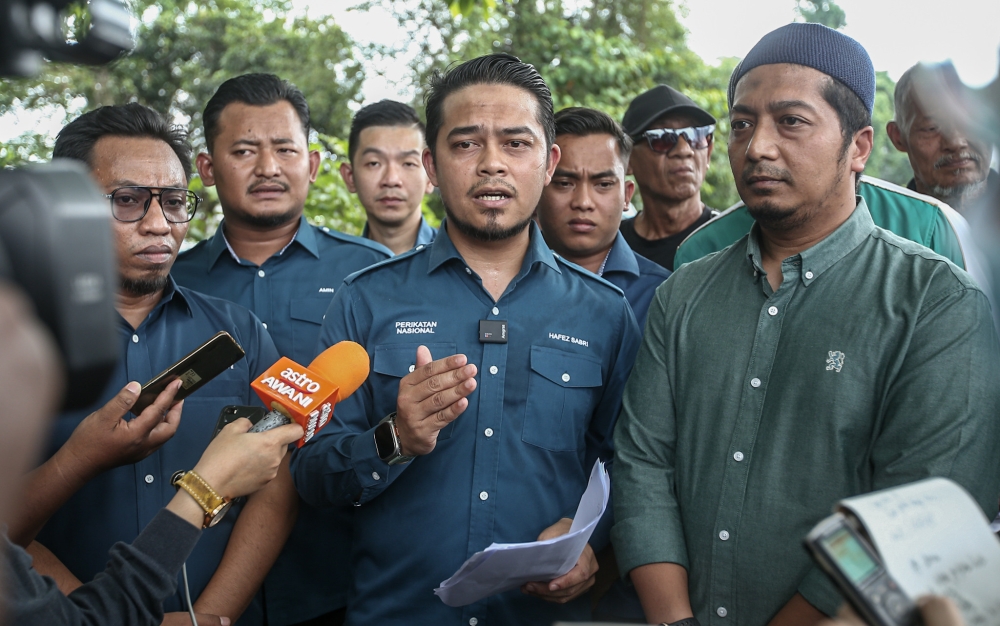 Manjoi assemblyman Mohd Hafez Sabri with other Perikatan Nasional supporters lodged a police report against DAP chairman Lim Guan Eng at the Ipoh police district headquarters in Ipoh, Perak, July 10, 2023. — Picture by Farhan Najib