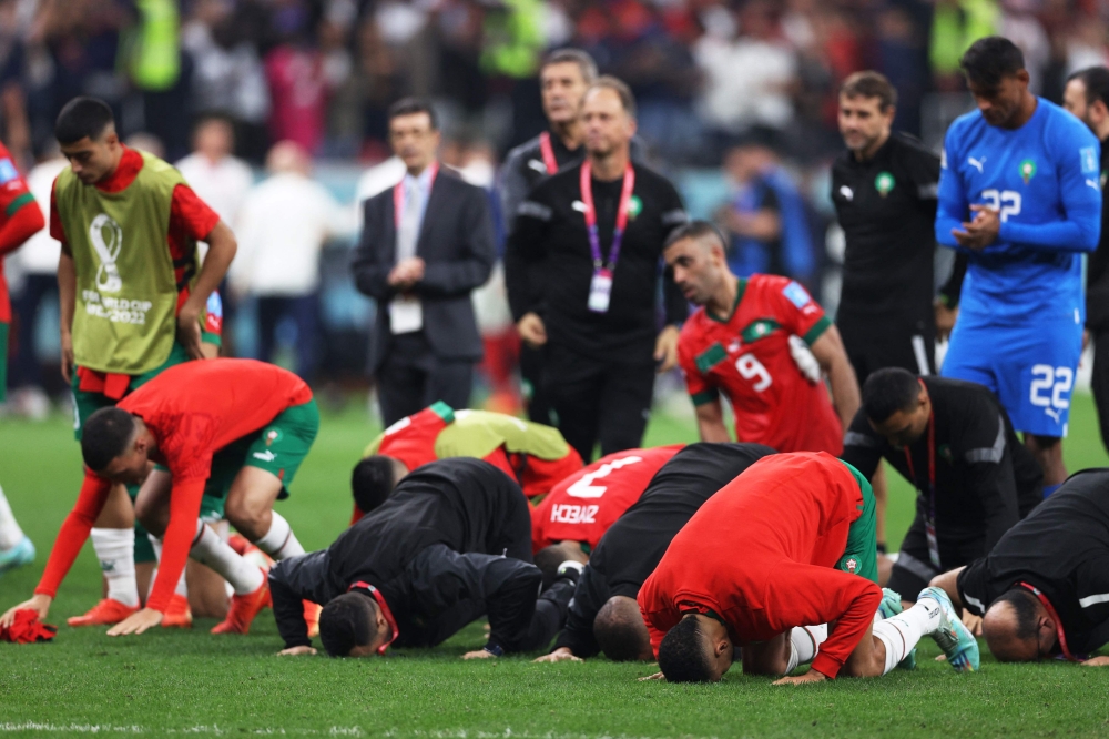 Morocco’s players pray and thank the crowd after losing 2-0 in the Qatar 2022 World Cup semi-final match against France at the Al-Bayt Stadium in Al Khor, north of Doha, December 14, 2022. — AFP pic
