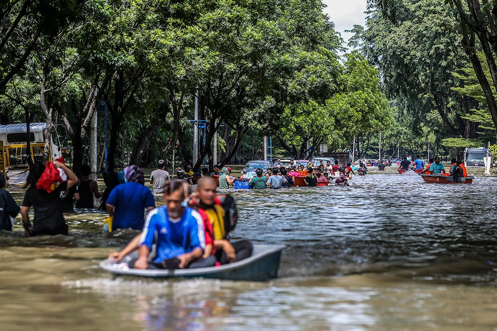 Flood victims seen wading through the floods in Taman Sri Muda Section 25 Shah Alam, December 20, 2021. MyHutan said 83 per cent of Malaysian youths in its recent survey said climate change was an important issue for them, while 83 per cent in the same survey also said they feel afraid for their future with climate change risks (such as flash floods, heatwaves) in the horizon. — Picture by Hari Anggara