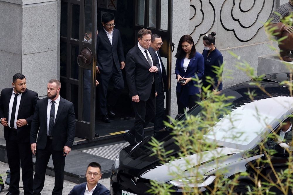 Tesla Chief Executive Officer Elon Musk walks next to Tesla Senior Vice President Tom Zhu and Vice President Grace Tao as he leaves a restaurant in Beijing, China May 31, 2023. — Reuters pic