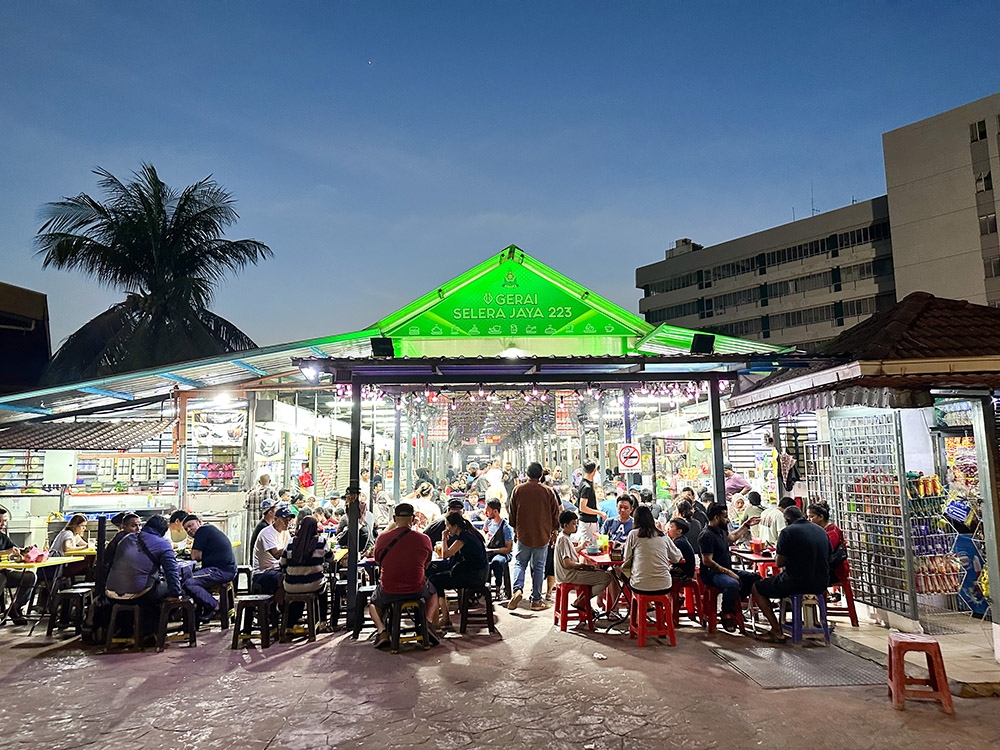 The food court is bustling at night with hungry patrons looking for a quick food fix.