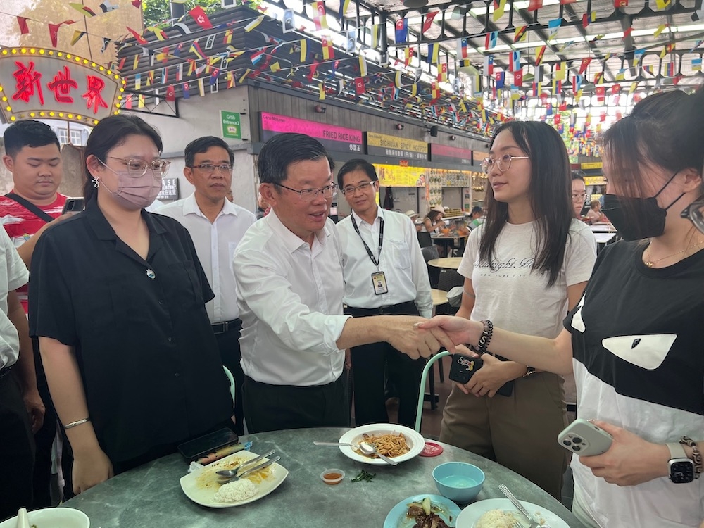Caretaker Penang chief minister Chow Kon Yeow shaking hands with people at the New World Park hawker centre. — Picture by Opalyn Mok