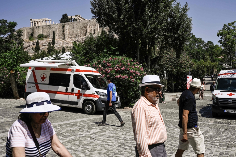 A photo shows mobile units of the Hellenic Red Cross, used to handout bottles of water, parked at the bottom of the Acropolis hill in Athens, on July 14, 2023. — AFP pic