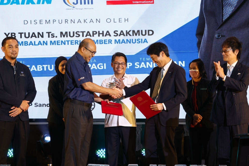 Human Resources deputy minister Mustapha Sakmud (centre) witnesses the signing of the MoU between the Industrial Training Institute and Daikin Malaysia in Sandakan July 15, 2023. — Bernama pic