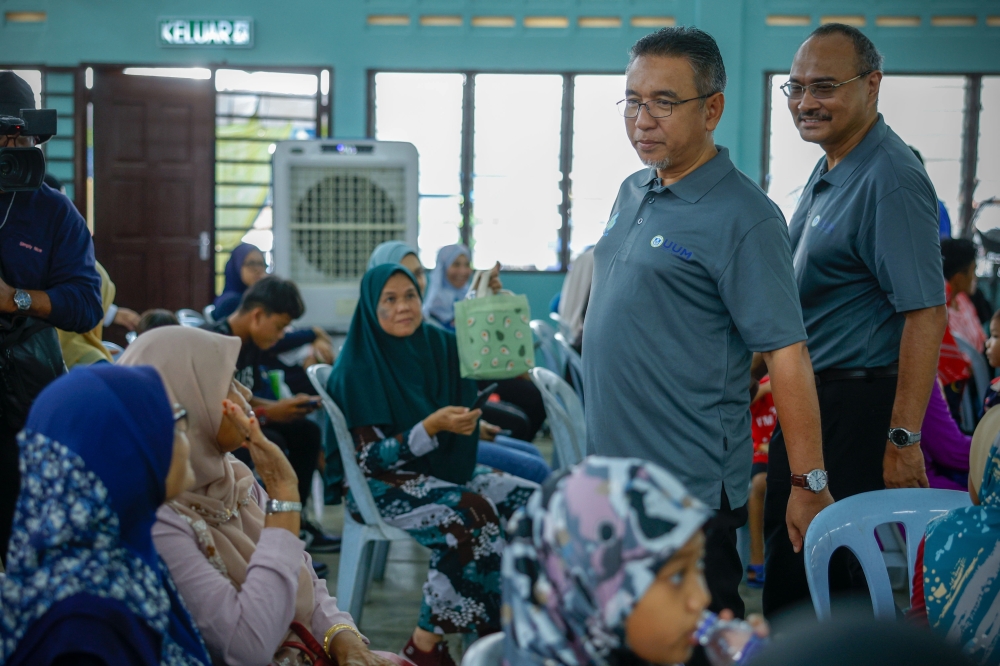 Deputy Minister of Defence Adly Zahari (2nd right) and Melaka Socso director Abd Razak Omar attend a Socso CSR and Outreach Programme at Felda Tun Ghafar, Hutan Percha in Alor Gajah July 15, 2023. — Bernama pic